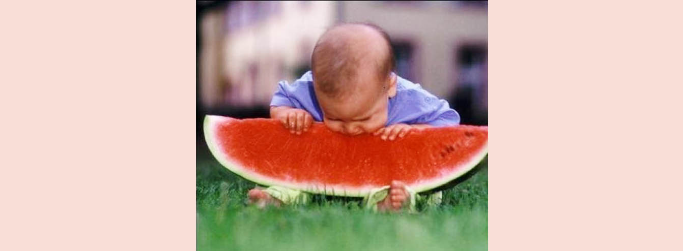 Baby eating large Melon Slice
